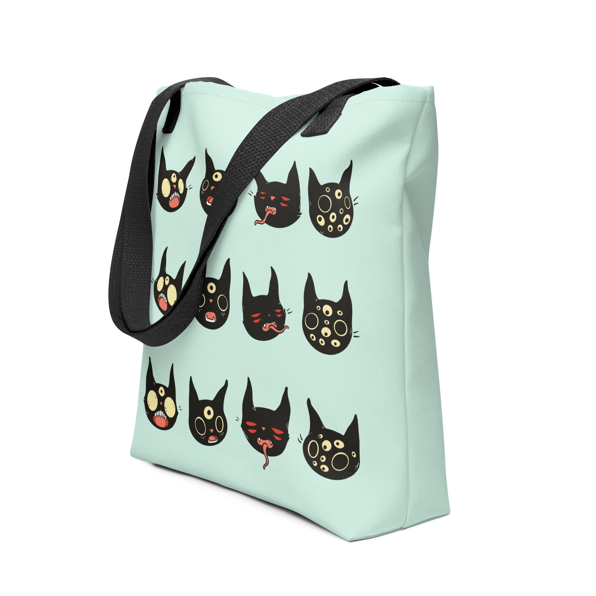 Tote bag featuring hand-drawn black cat faces on a mint green background, perfect for everyday essentials.