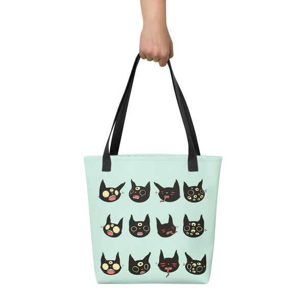 Tote bag with hand-drawn black cat faces design, spacious for daily use, featuring dual cotton handles.