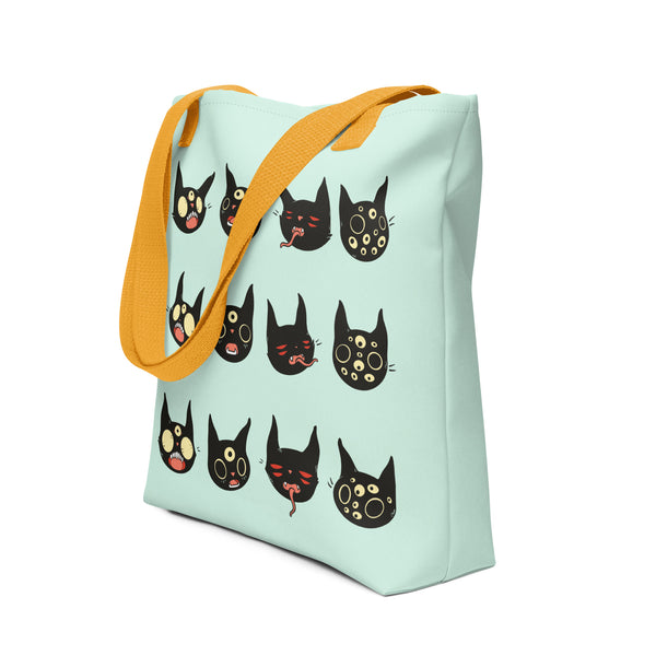 Spacious tote bag featuring hand-drawn black cat faces, printed on both sides, with yellow handles for easy carrying.