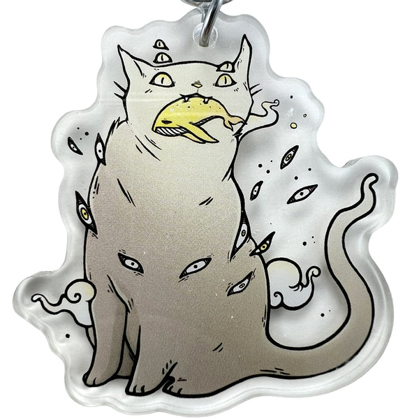 Acrylic keychain featuring a whimsical cat illustration with multiple eyes and a fish in its mouth, Cat & Whale, Keychain.