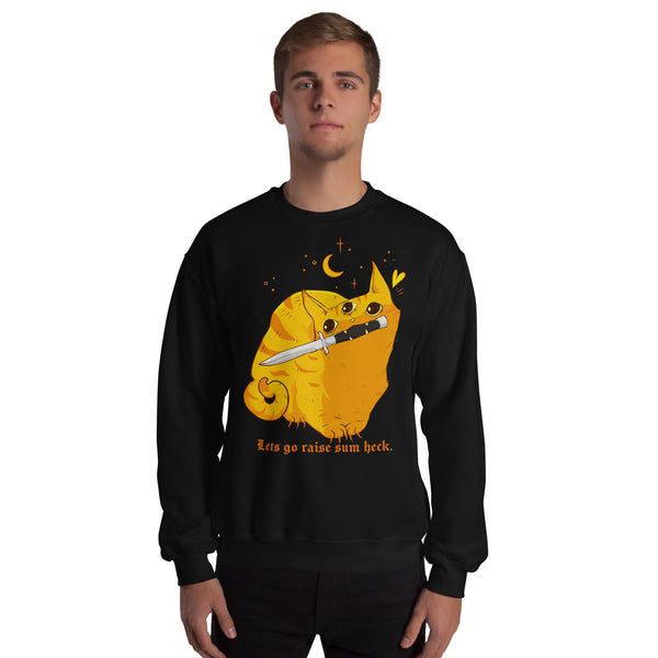 A man wearing a black crewneck sweatshirt with a graphic of a yellow cat holding a sword and the text 'Let's go raise sun heck.' on a plain white background.
