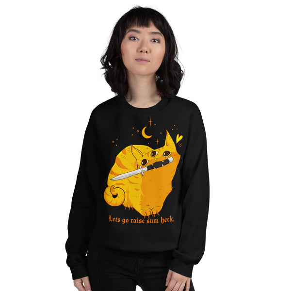 A woman modeling a black crewneck sweatshirt with a graphic of an orange cat holding a knife, with the text 'Lets go raise sun heck.' below it.