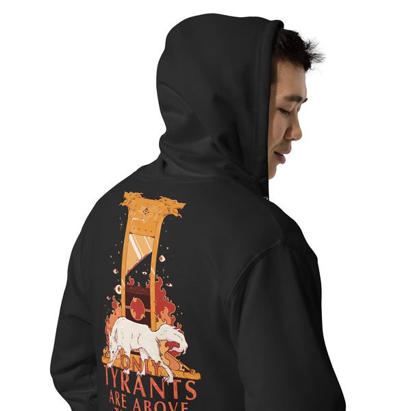 A man wearing a black hoodie, shown from the back and side profile. The hoodie features a large graphic print on the back with an hourglass, a white wolf, and the text 'TYRANTS ARE ABOVE' in orange and red.