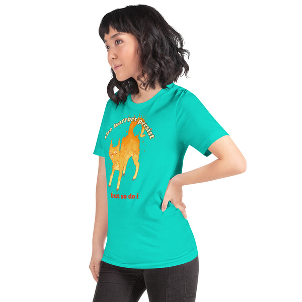 Unisex turquoise t-shirt featuring a fire cat illustration and the quote 'The horrors persist but so do I.'