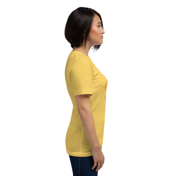 A side view of a woman wearing The Curse Has Been Undone, Unisex T-Shirt in yellow, showcasing its soft fit and graphic design.