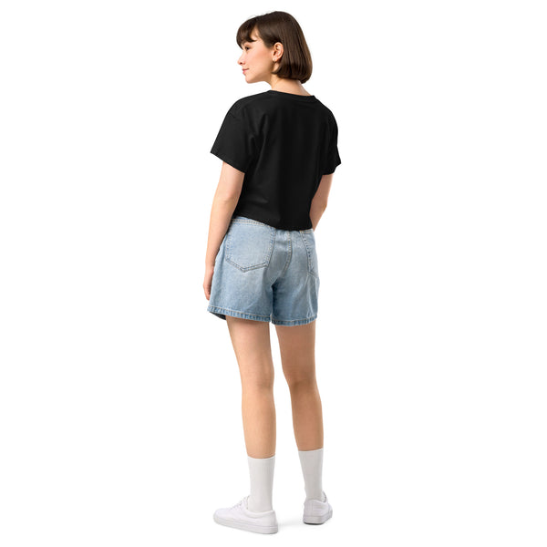 Woman wearing a black relaxed crop top with shorts, back view. Casual summer outfit with a comfortable fit.