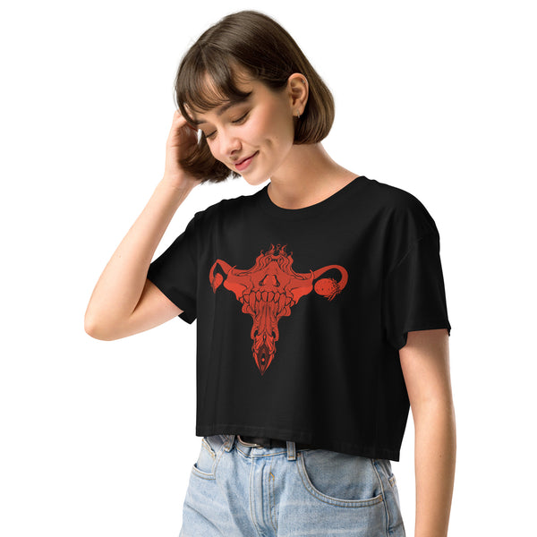 Woman wearing black crop top with hand-drawn death metal uterus design, combining alt and witchy aesthetics, relaxed fit, cotton.