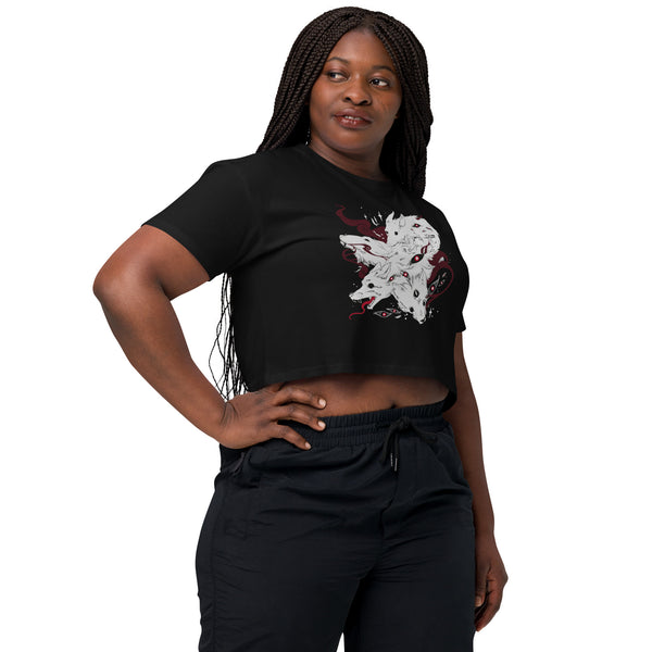 Model wearing Many Wolves, Relaxed Crop Top featuring original wolf illustration on a black background.