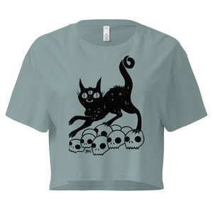 Black crop top featuring a hand-drawn illustration of a black cat on a pile of skulls, relaxed fit, comfortable style.
