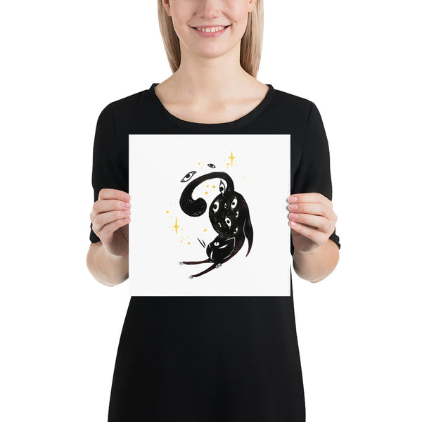 Person holding a matte art print of a stretching black cat illustration with stars, ideal for home decor.