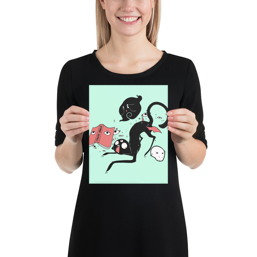 Woman holding Kuro black cat matte art print poster featuring original illustration on mint green background.