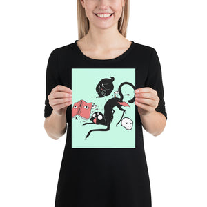 Woman holding Kuro black cat matte art print poster featuring original illustration on mint green background.