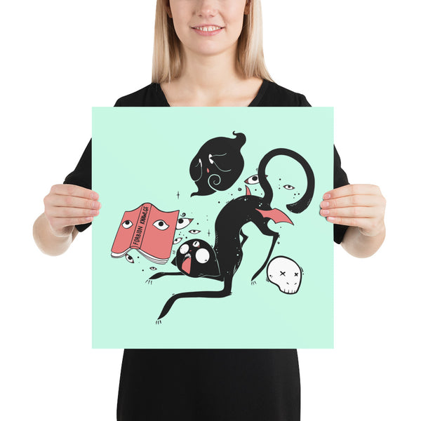 A person holding a matte art print of Kuro, a black cat, featuring whimsical illustrations on a mint background.