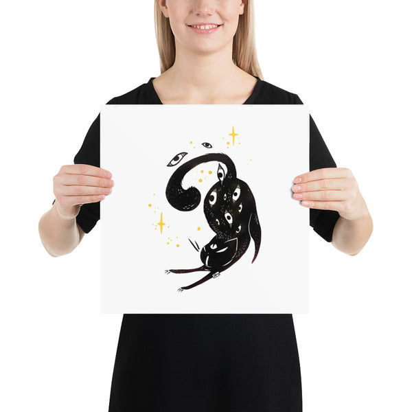 Matte art print of a stretching black cat with stars, held by a woman, showcasing original illustration on archival paper.