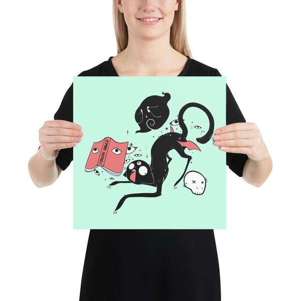 Kuro black cat matte art print poster held by a person, featuring whimsical illustrations on a mint background.